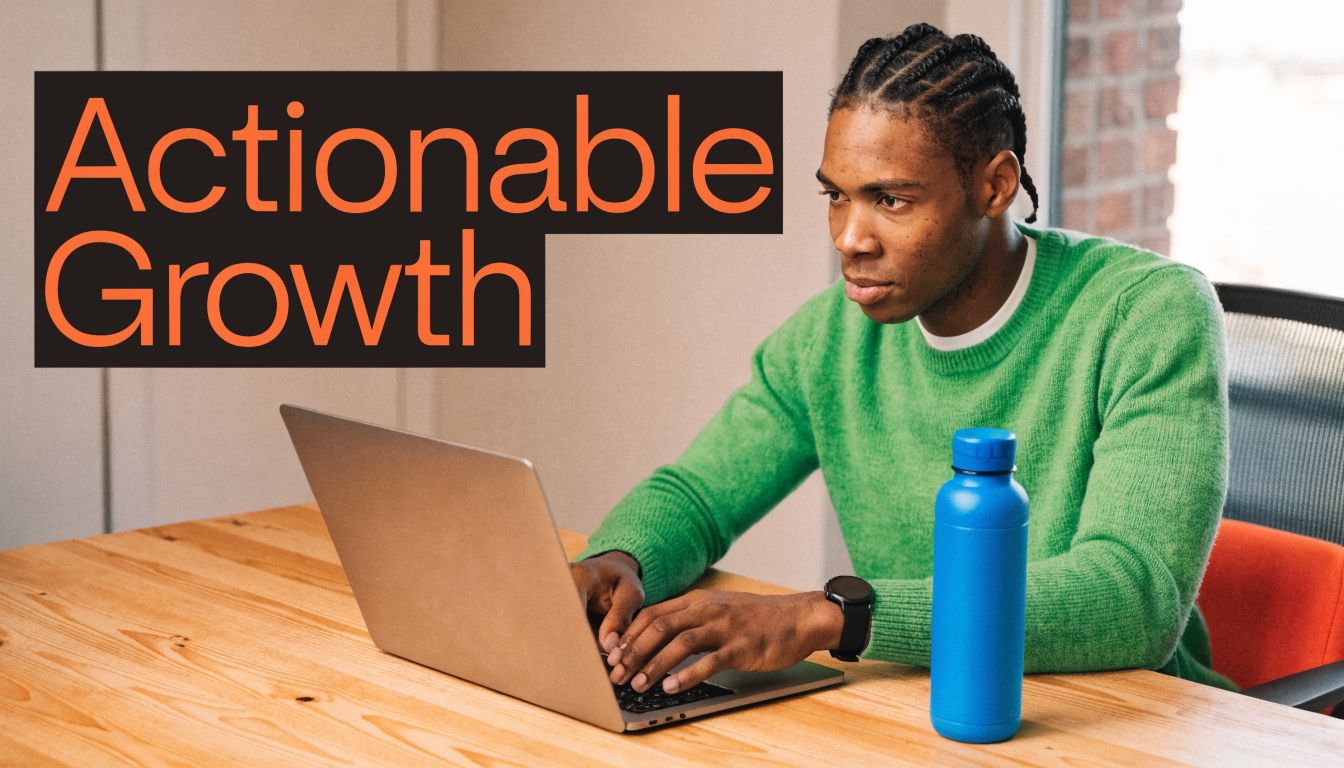 A young man wearing a green sweater working on a laptop with the text Actionable Growth above him.