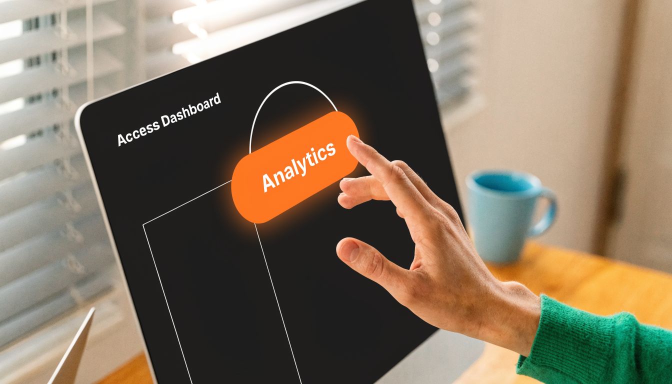 A person reaches out to touch an interactive analytics button displayed on a computer screen monitor.