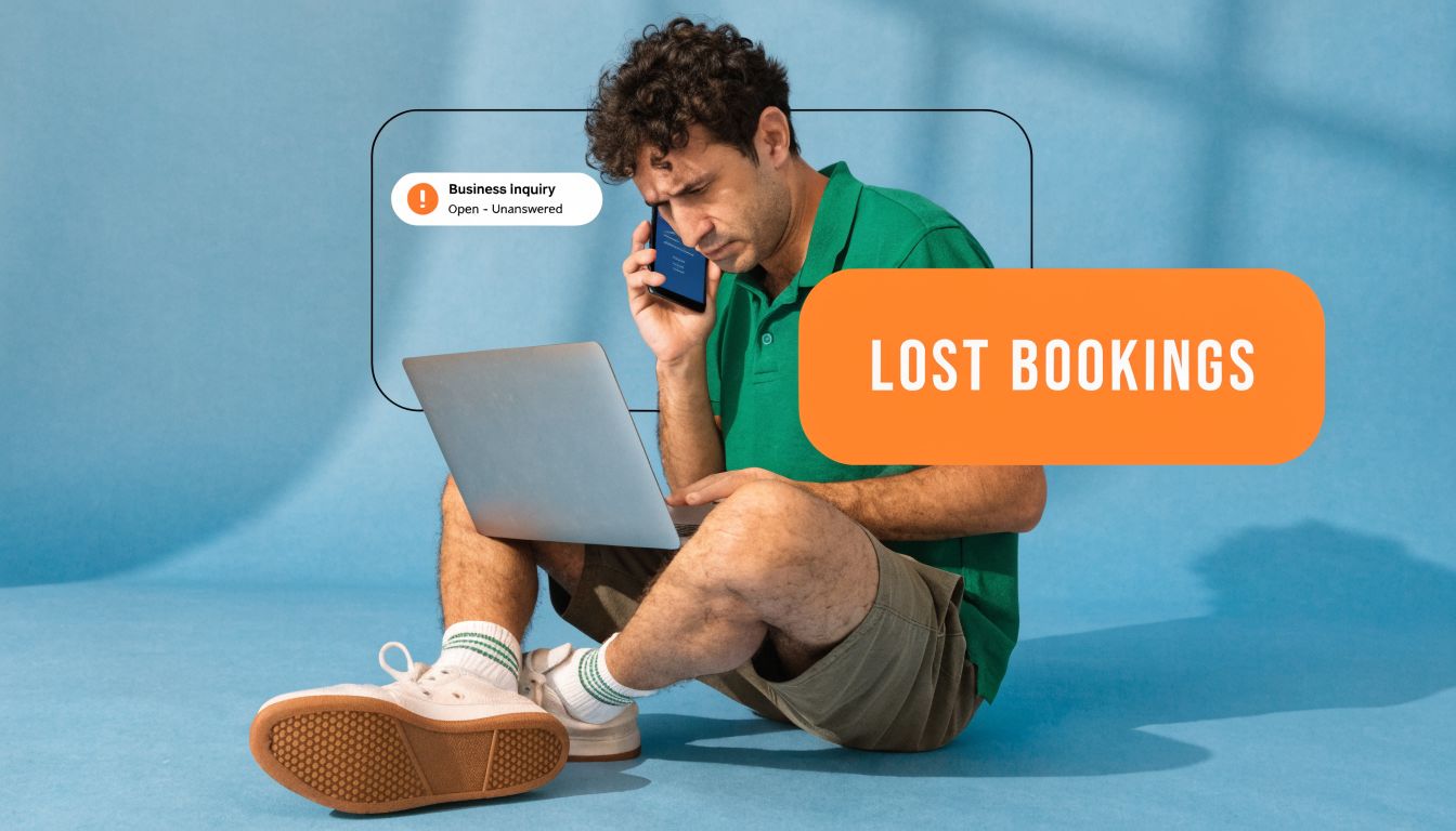 A man looking stressed while sitting on the floor using a laptop and a mobile phone.