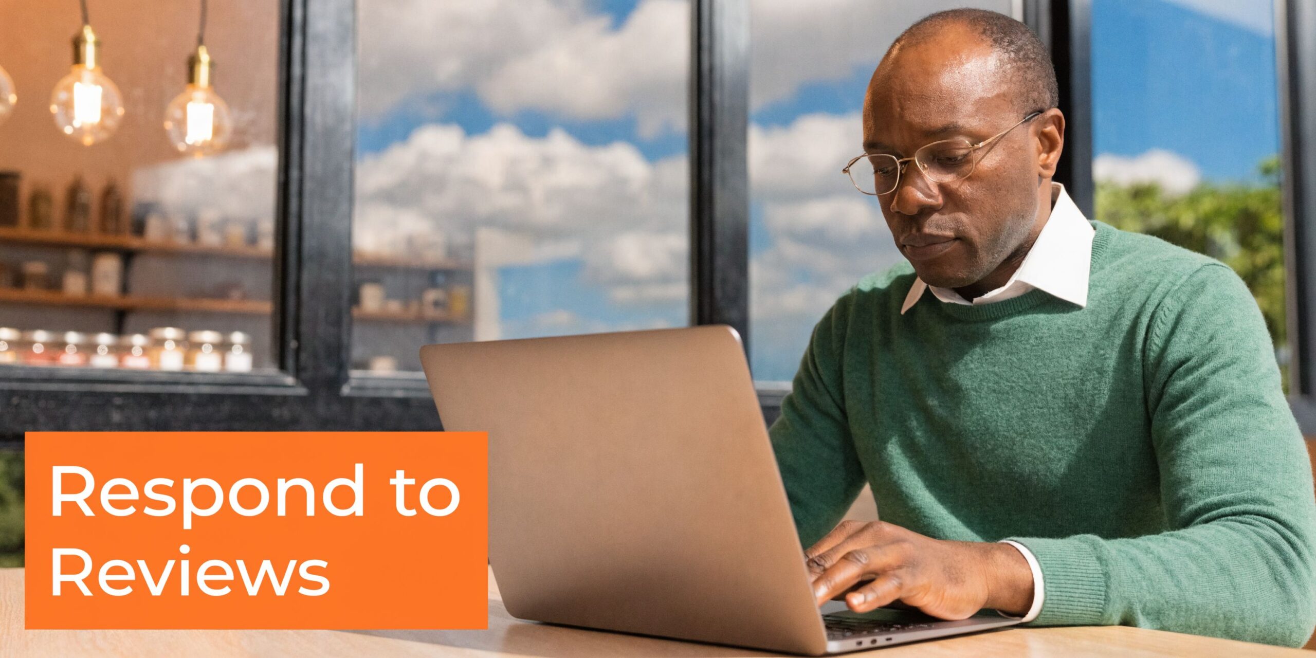 A professional man wearing glasses typing on a laptop with a Respond to Reviews orange graphic.